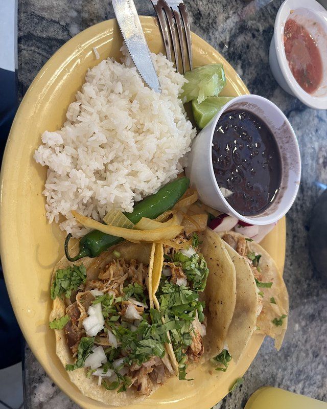 A taco plate with white rice, black beans and avocado