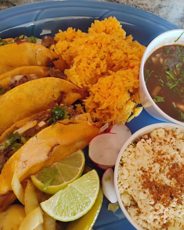 Birria platter with a cup of consommé, rice and horchata